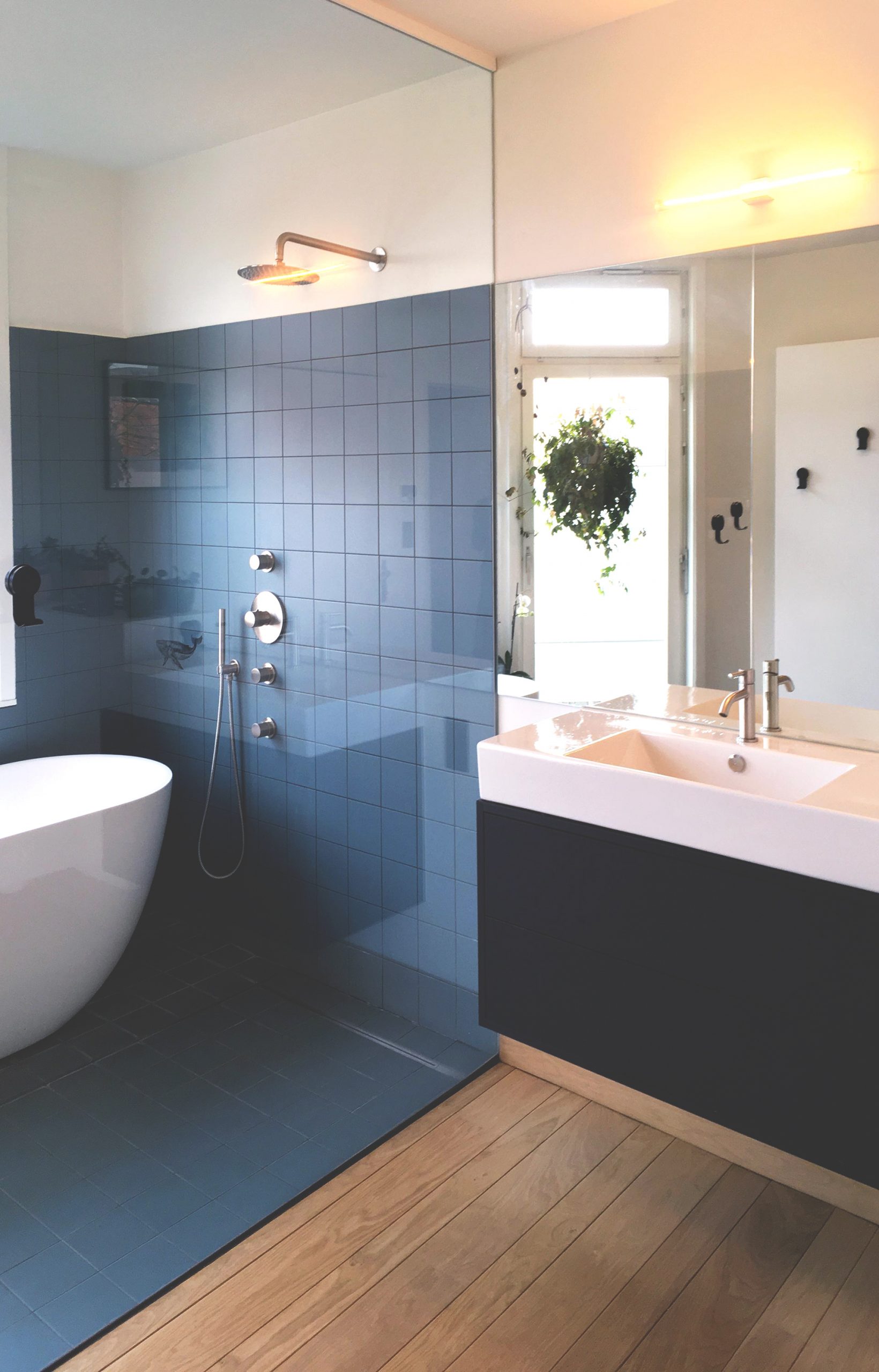 photograph of a bathtub shower combination with blue tiles and wooden parquet-(c) an vanderhoydonck